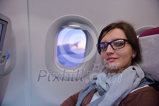 happy young tourist woman is sitting in the airplane looking windov and travel to summer vacation happy young tourist woman is sitting in the airplane looking windov and travel to summer vacation