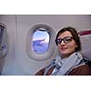 happy young  tourist  woman is sitting in the airplane looking windov and travel to summer vacation