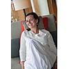 happy young woman relax at home on sofa in bright living room and watching tv