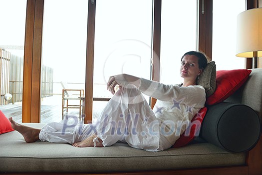 happy young woman relax at home on sofa in bright living room and watching tv happy young woman relax at home on sofa in bright living room and watching tv