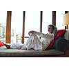 happy young woman relax at home on sofa in bright living room and watching tv