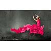 Young attractive woman in pink dress jumping high