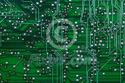 Printed green computer circuit board with many electrical components Printed green computer circuit board with many electrical components