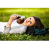 Young woman using her tablet computer while relaxing outdoors in a park on a lovely spring day