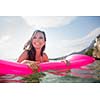 Pretty, young woman enjoying a day at the beach, relaxing on inflatable mattress