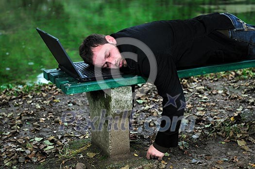 young businessman sleeping with head on laptop young businessman sleeping with head on laptop