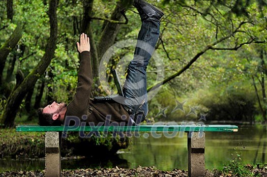 one young businessman working on laptop outdoor with green nature in background one young businessman working on laptop outdoor with green nature in background