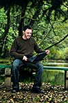 one young businessman working on laptop outdoor with green nature in background