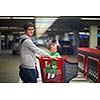 young mother with baby in shopping mall supermarket store buying food and grocery