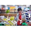 young mother with baby in shopping mall supermarket store buying food and grocery