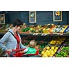 young mother with baby in shopping mall supermarket store buying food and grocery