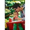 young mother with baby in shopping mall supermarket store buying food and grocery