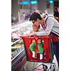 young mother with baby in shopping mall supermarket store buying food and grocery