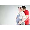 young family couple together in studio isolated on white. happy and waiting for baby
