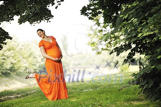 beautiful young happy pregnant woman outdoor in bright nature in orange dress beautiful young happy pregnant woman outdoor in bright nature in orange dress