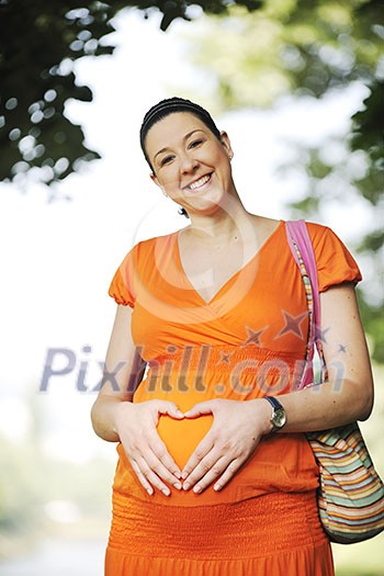 beautiful young happy pregnant woman outdoor in bright nature in orange dress beautiful young happy pregnant woman outdoor in bright nature in orange dress