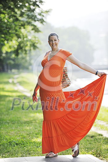 beautiful young happy pregnant woman outdoor in bright nature in orange dress beautiful young happy pregnant woman outdoor in bright nature in orange dress