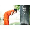 beautiful young happy pregnant woman outdoor in bright nature in orange dress