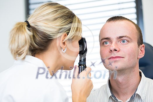 Optometry concept - handsome young man having her eyes examined by an eye doctor Optometry concept - handsome young man having her eyes examined by an eye doctor