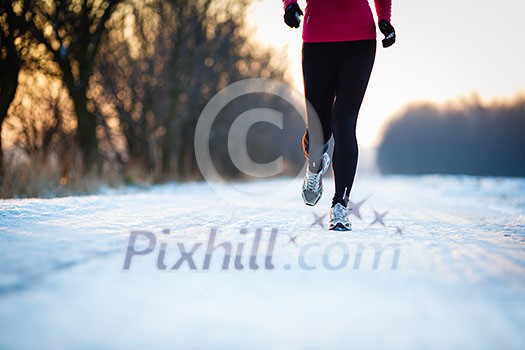 Winter running - Young woman running outdoors on a cold winter day