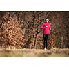 Young woman running outdoors on a lovely sunny winter/fall day