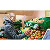 Beautiful, young woman shopping for fruits and vegetables in produce department of a grocery store/supermarket (shallow DOF; color toned image)