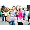 Two female tourists walking along the Charles Bridge while sightseeing in Prague, the historical capital of the Czech Republic (color toned image; shallow DOF)