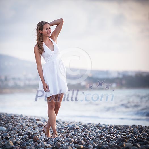Young woman on the beach enjoying a warm summer evening Young woman on the beach enjoying a warm summer evening
