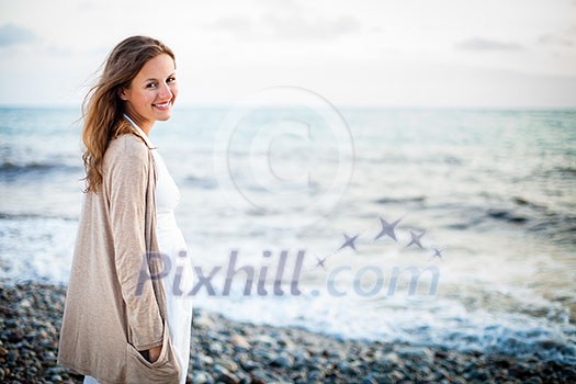 Young woman on the beach enjoying a warm summer evening Young woman on the beach enjoying a warm summer evening