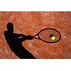 shadow of a tennis player in action on a tennis court (conceptual image with a tennis ball lying on the court and the shadow of the player positioned in a way he seems to be playing it)
