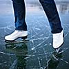 Young woman ice skating outdoors on a pond on a freezing winter day