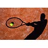 shadow of a tennis player in action on a tennis court (conceptual image with a tennis ball lying on the court and the shadow of the player positioned in a way he seems to be playing it)