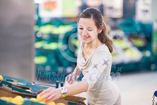 Beautiful youn woman shopping for fruits and vegetables in produce department of a grocery store/supermarket (shallow DOF; color toned image) Beautiful youn woman shopping for fruits and vegetables in produce department of a grocery store/supermarket (shallow DOF; color toned image)