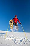 Young man having fun while snowshoeing outdoors on a lovely snowy winter day