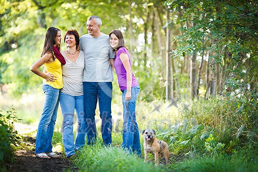 Family portrait - Family of four with a cute dog outdoors Family portrait - Family of four with a cute dog outdoors
