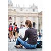 Pretty young female tourist studying a map at St. Peter's square in the Vatican City in Rome