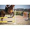 Young woman show jumping with horse