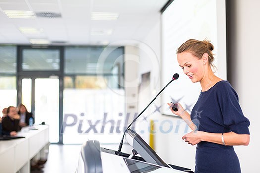 Pretty, young business woman giving a presentation in a conference/meeting setting (shallow DOF; color toned image) Pretty, young business woman giving a presentation in a conference/meeting setting (shallow DOF; color toned image)