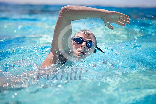 Young man swimming the front crawl/freestyle in a pool Young man swimming the front crawl/freestyle in a pool