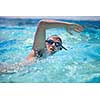 Young man swimming the front crawl/freestyle in a pool