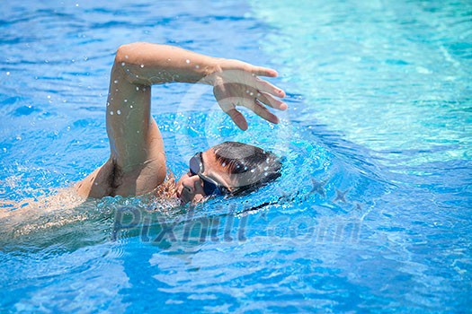 Young man swimming the front crawl/freestyle in a pool Young man swimming the front crawl/freestyle in a pool