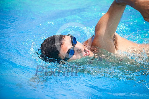 Young man swimming the front crawl in a pool Young man swimming the front crawl in a pool