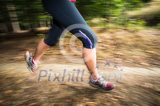Young woman running outdoors in a forest, going fast (motion blurred image) Young woman running outdoors in a forest, going fast (motion blurred image)
