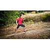 Young woman running outdoors in a forest, going fast (motion blurred image)