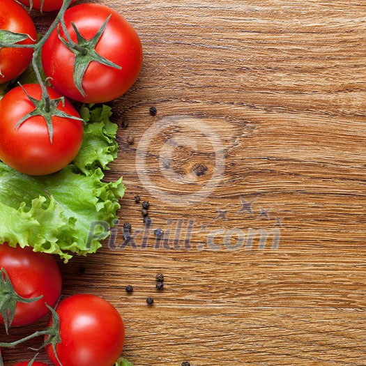 red tomatoes with green salad on wooden background red tomatoes with green salad on wooden background