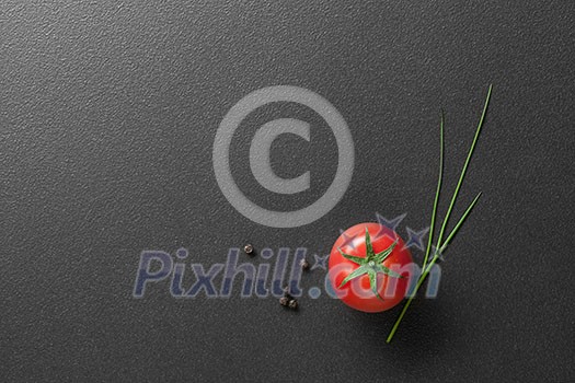 red tomato with green onion on black red tomato with green onion on black