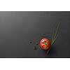 red tomato with green onion on black