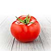 red tomato isolated on white wood