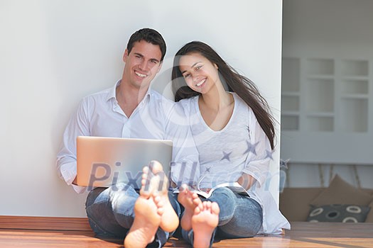 happy young relaxed couple working and playing on laptop computer at home happy young relaxed couple working and playing on laptop computer at home