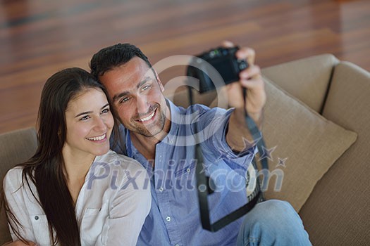 happy young couple playing with digital camera at home happy young couple playing with digital camera at home
